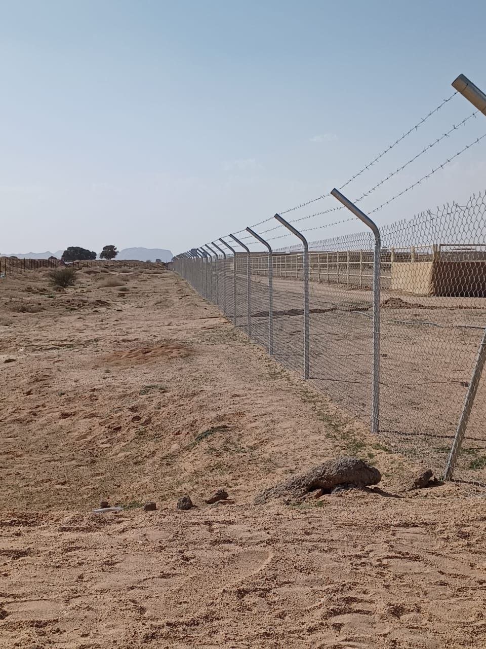 عامل يقوم بتركيب شبوك معدنية حول موقع مشروع